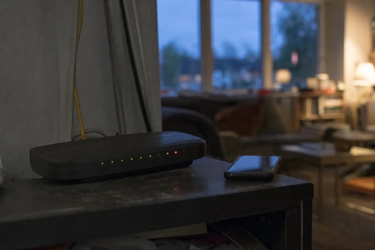 Router med rødt lys på en hylde i en stue om aftenen