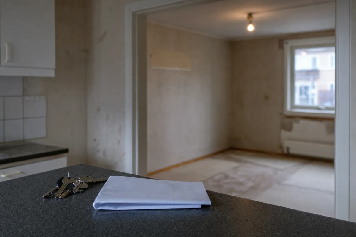 Nøgler og en lejekontrakt liggende på bordpladen i en tom lejlighed