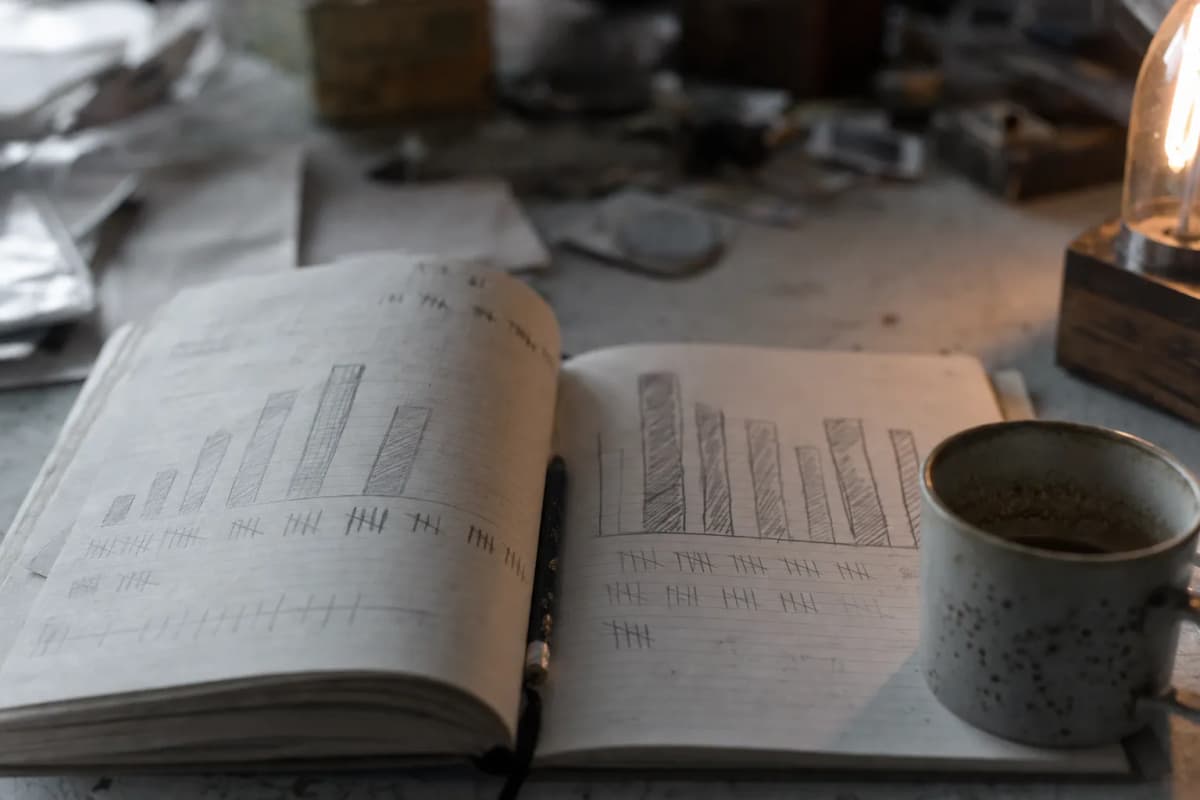 Notesbog med håndtegnede diagrammer ved siden af en kaffekop