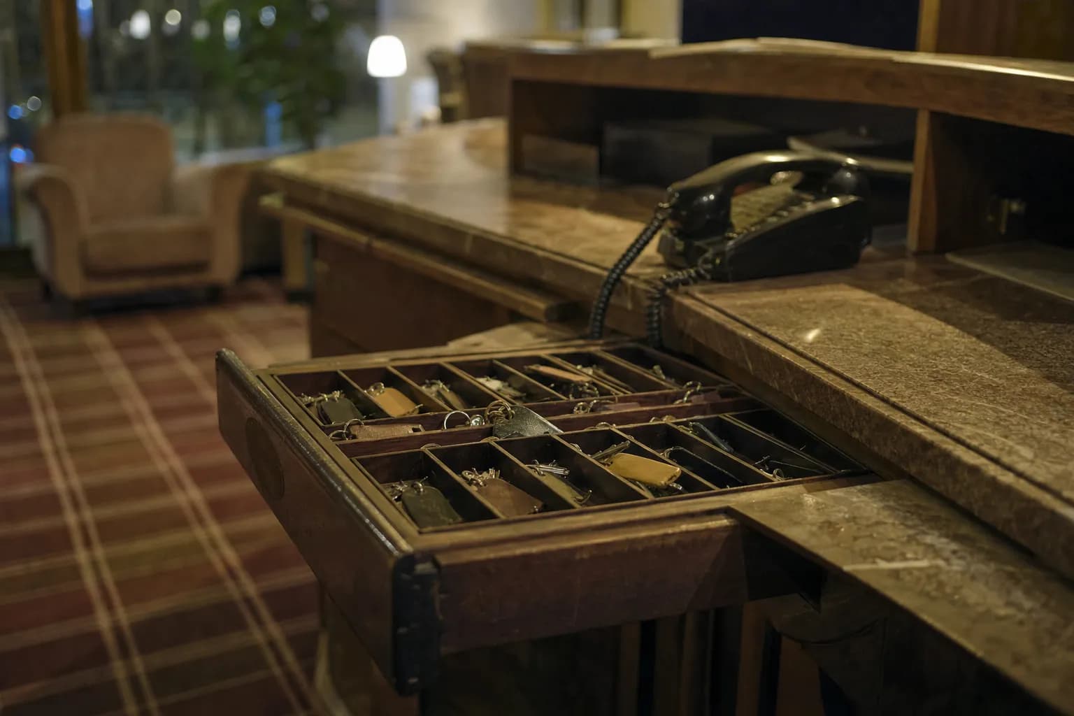 En concierge-disk i en hotellobby om kvelden med en åpen nøkkelskuff
