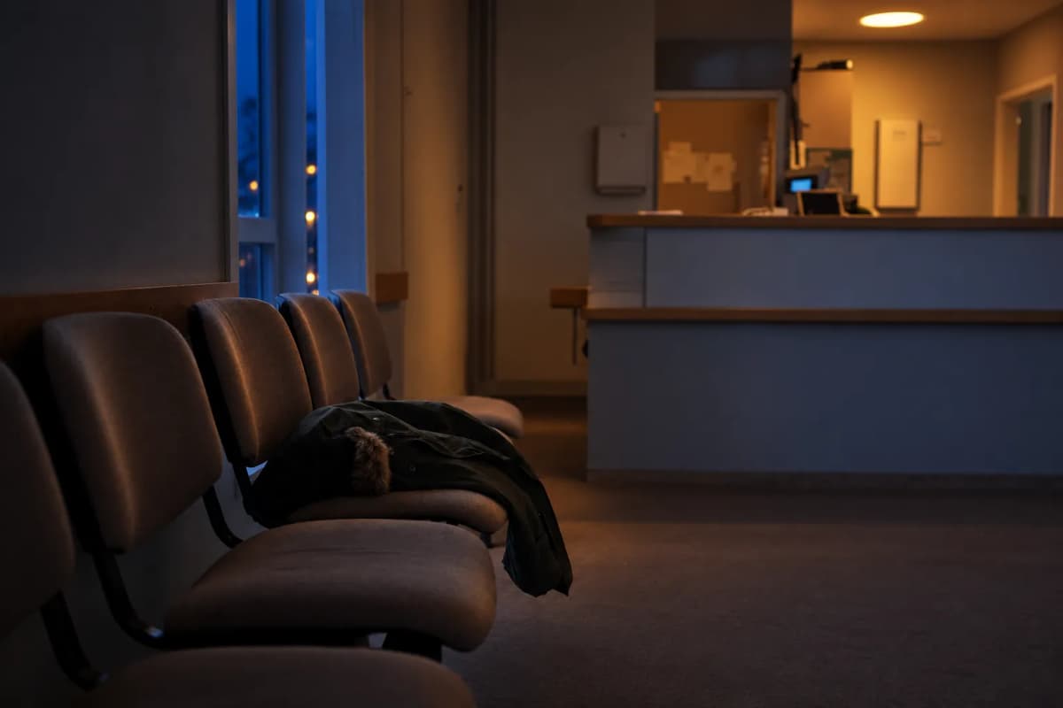 Venteværelse på en klinik med tomme stole og en receptionsskranke